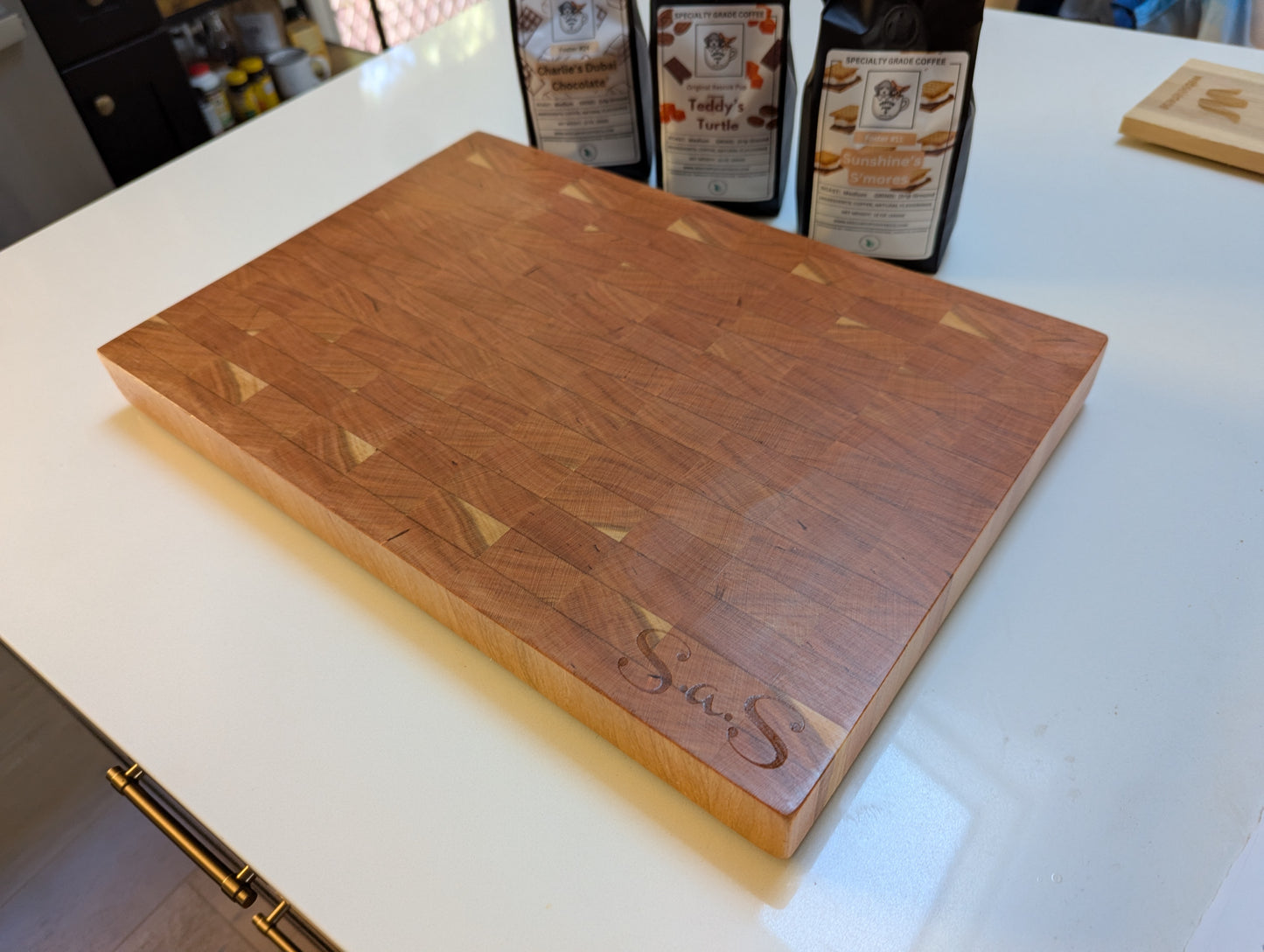 Wooden cutting board with 'S&S' branding on a white countertop.
