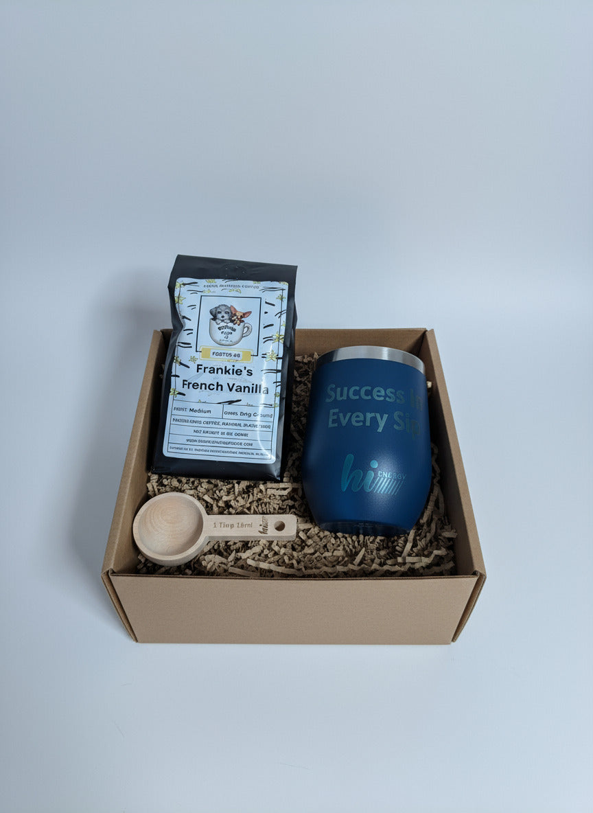 Box containing a blue tumbler with text, a coffee package, and a small white container.