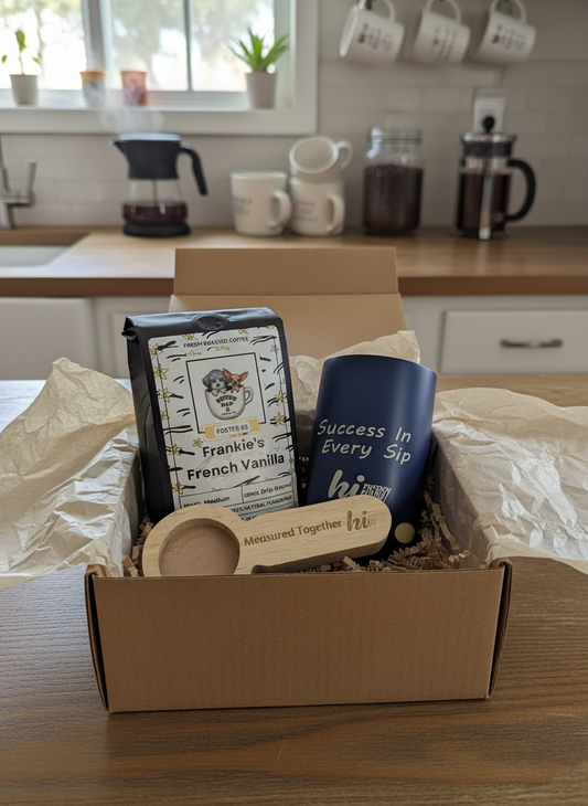 Box containing coffee beans, a mug, and a wooden spoon on a kitchen counter.