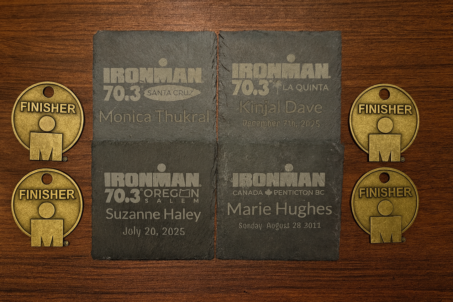 Ironman race finisher medals and name plates on a wooden surface