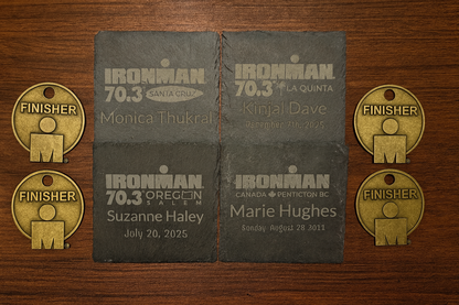Ironman race finisher medals and name plates on a wooden surface